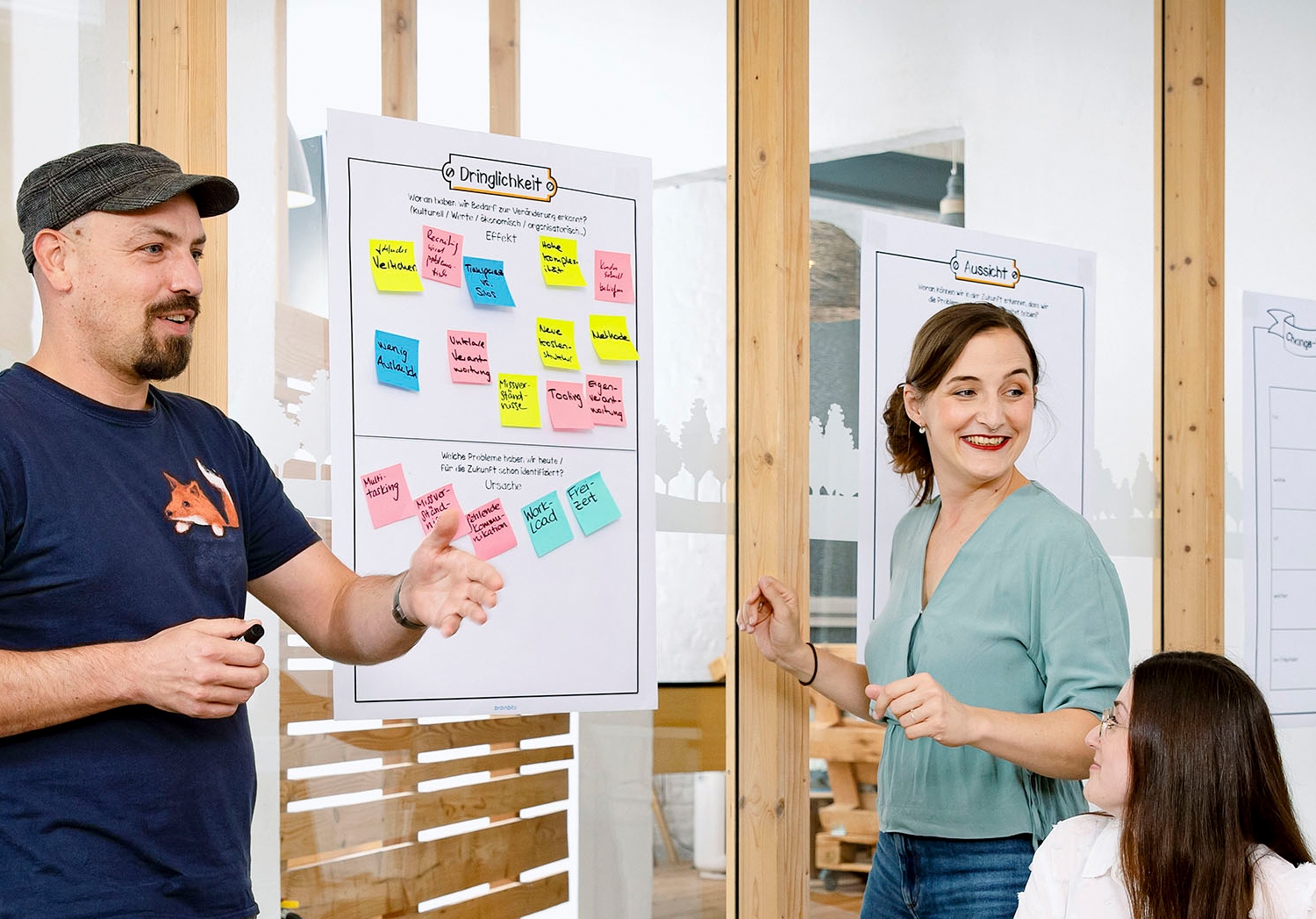 A consultant sticks dots on a paper full of Post-Its during a workshop.