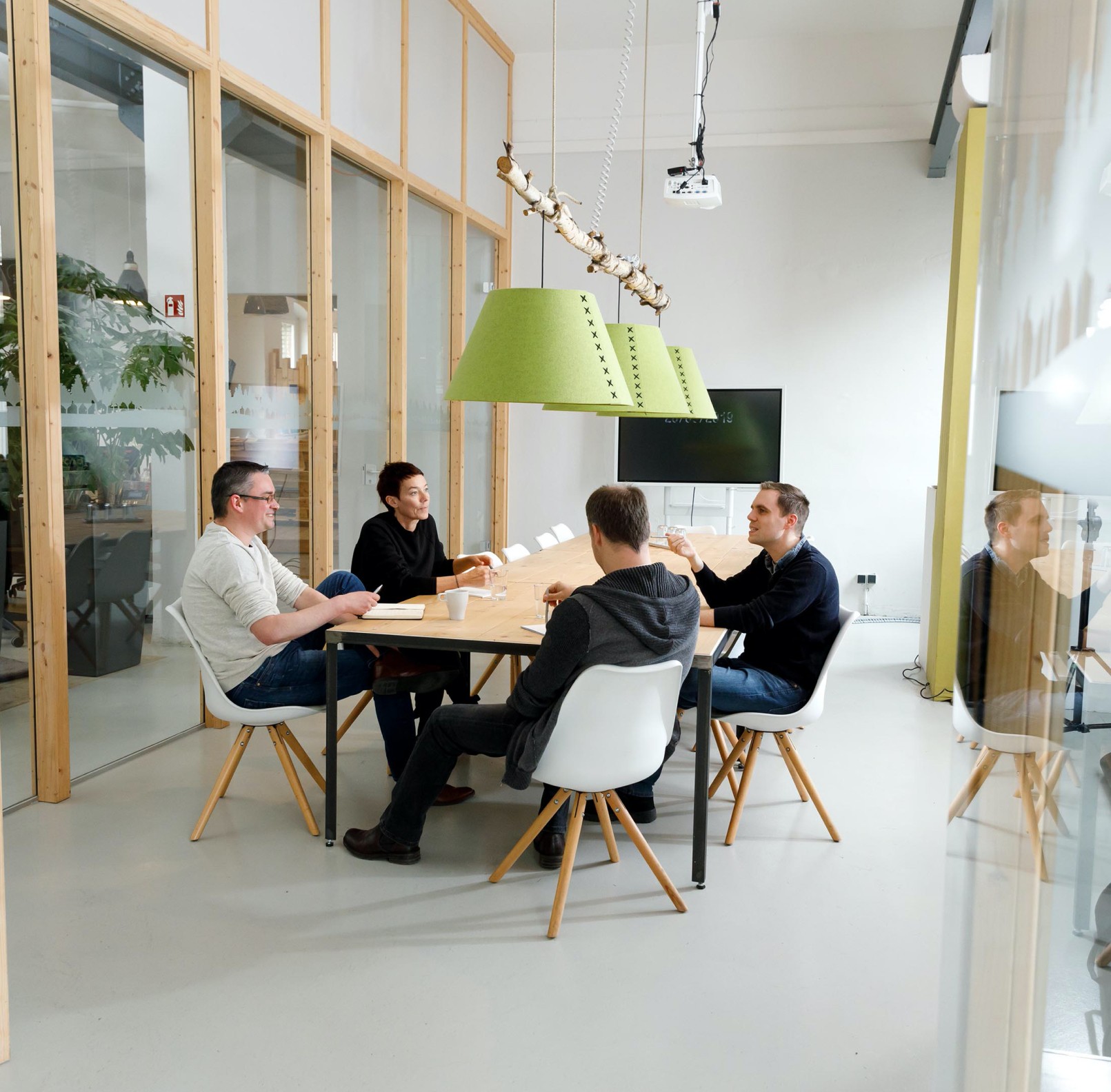 Four people sit around a table and consult