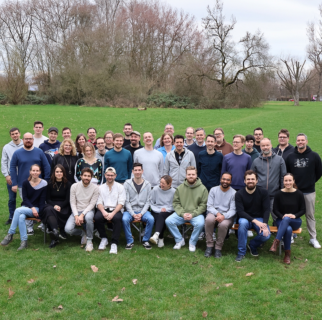 Gruppenfoto aller brainbits Mitarbeitenden auf einer grünen Wiese